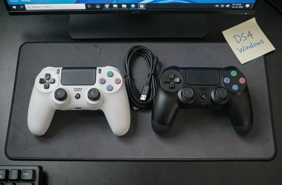 Comparaison flat-lay entre une manette Switch Pro et une manette PS4 DualShock 4 sur un bureau PC Windows 11